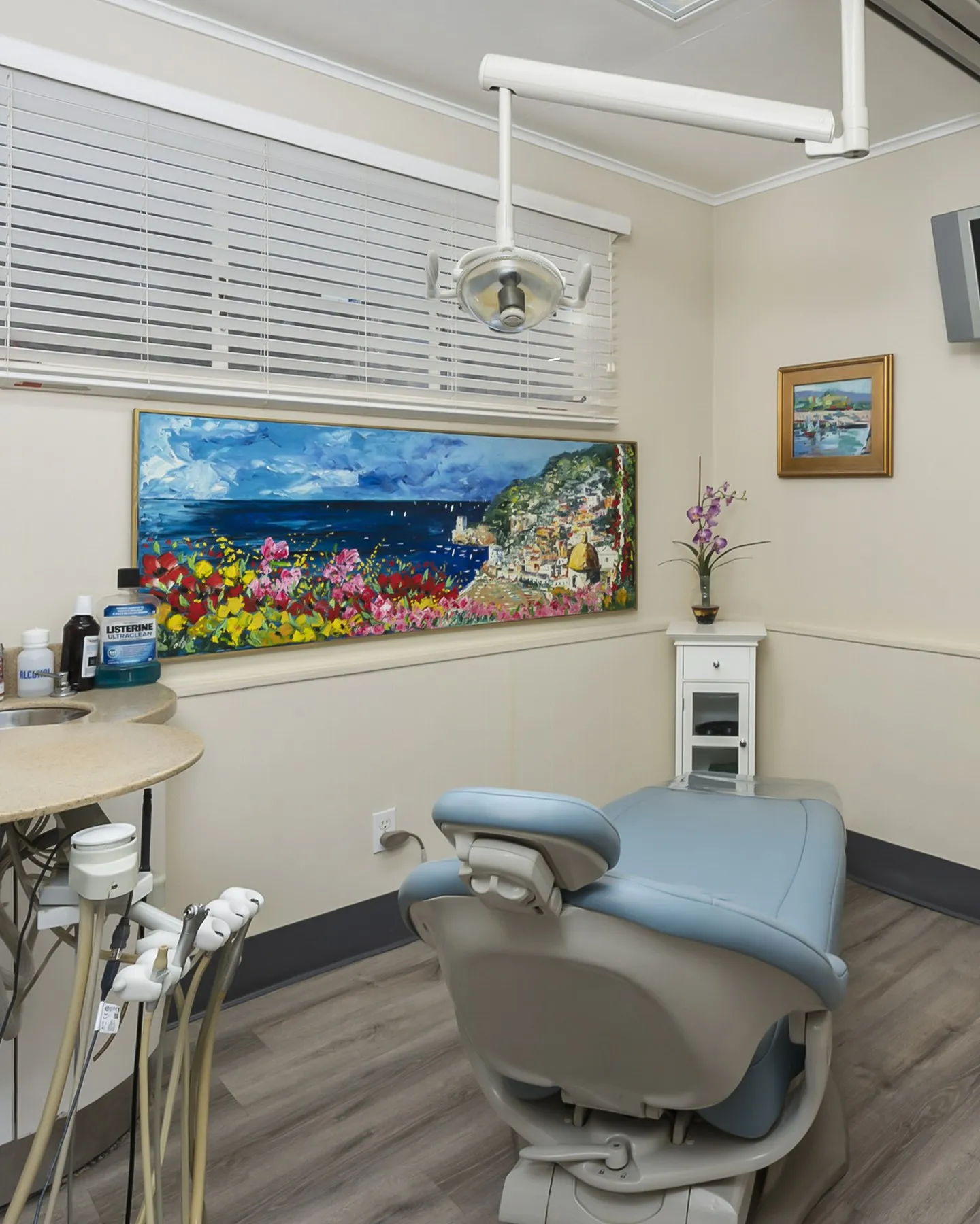 Treatment room with coastal artwork and a comfortable patient chair